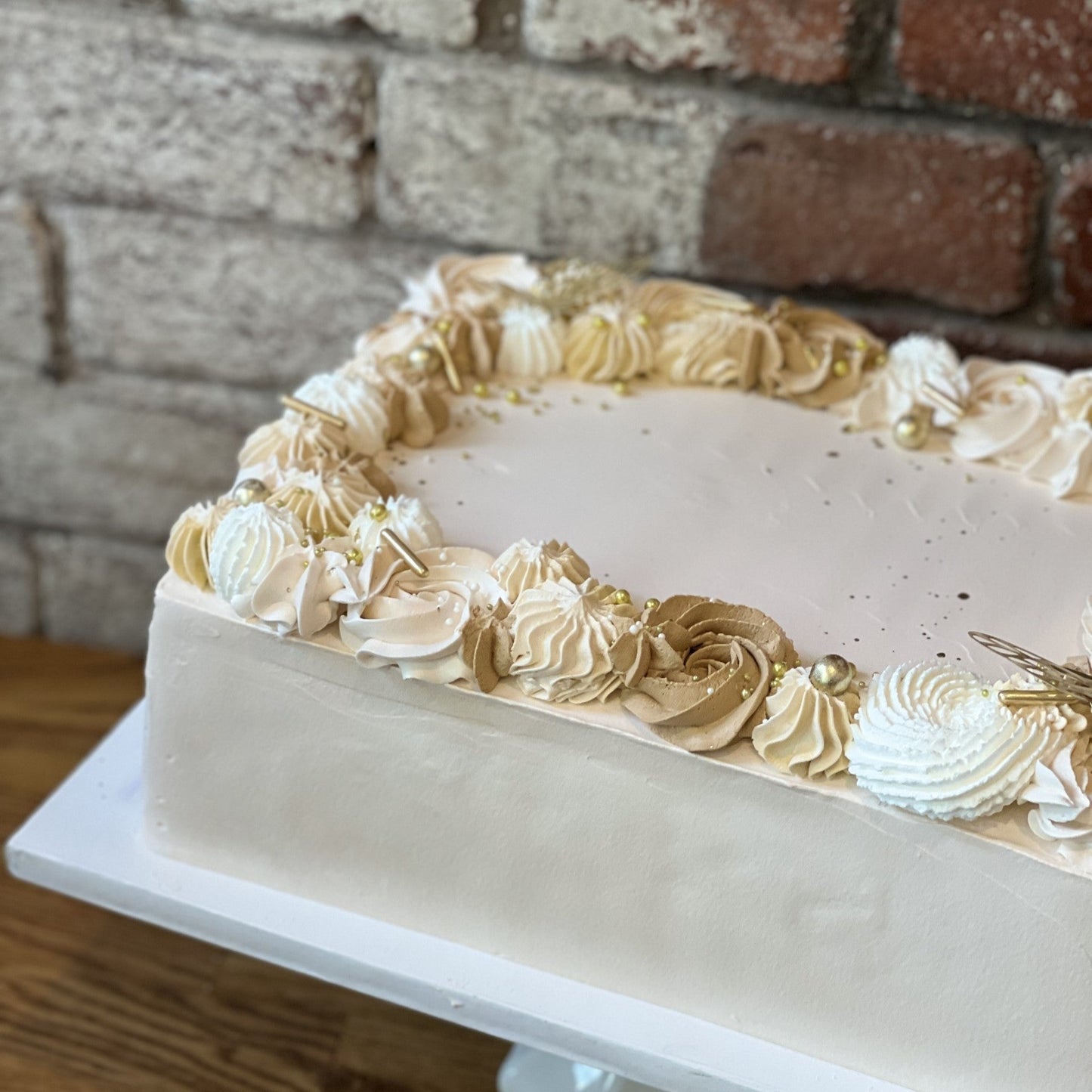 White sheet cake with gold design around the edges