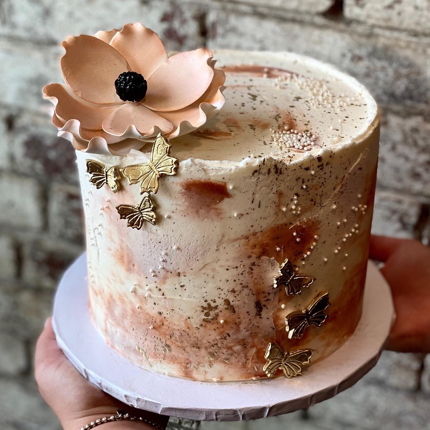 White and pink cake with goal butterflies