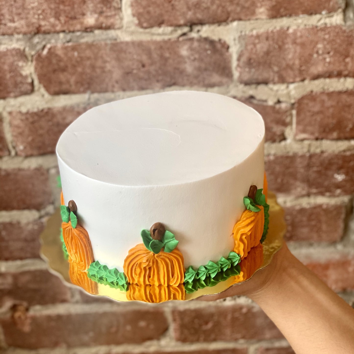 White cake decorated with orange pumpkin icing trim