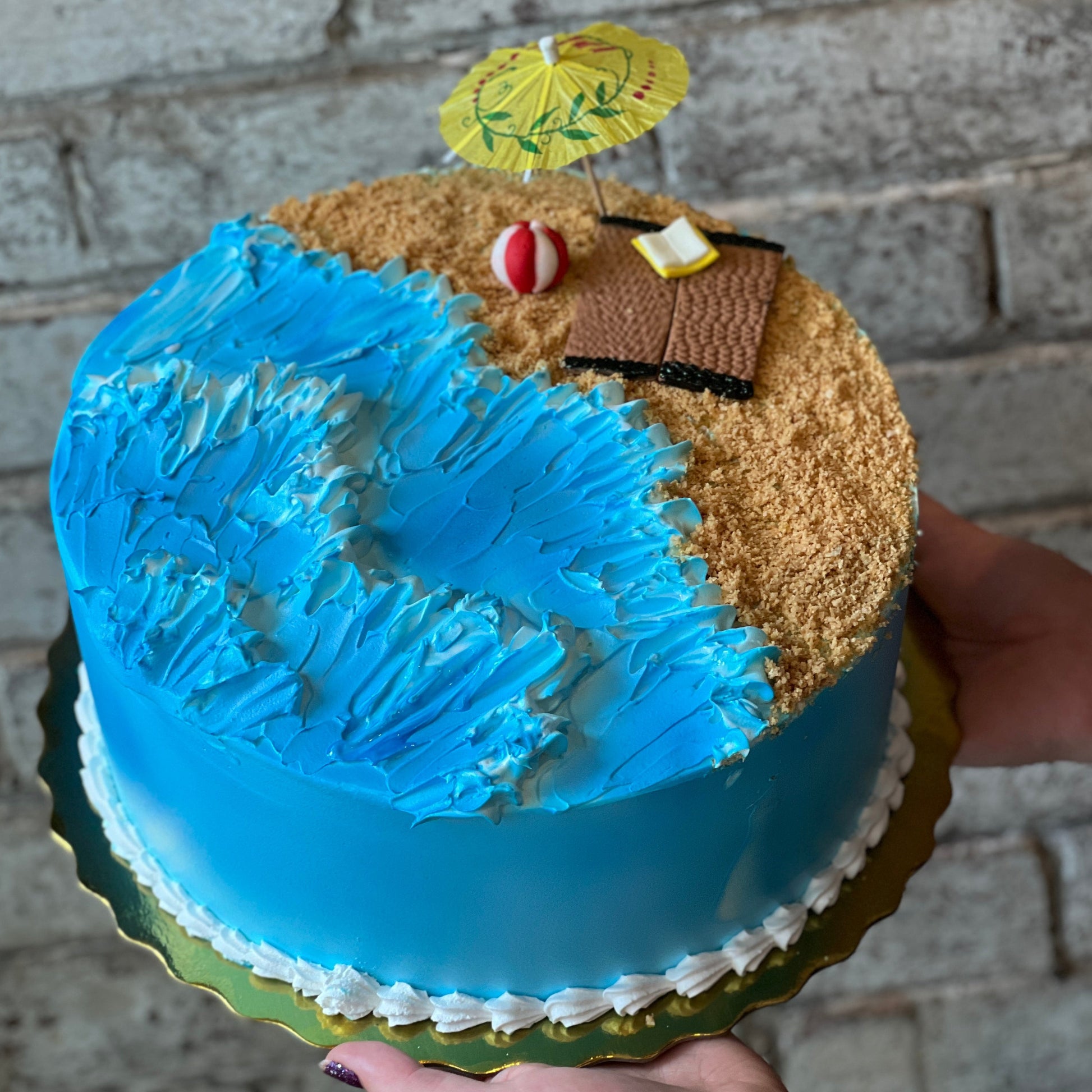 Beach-themed cake with waves and umbrella