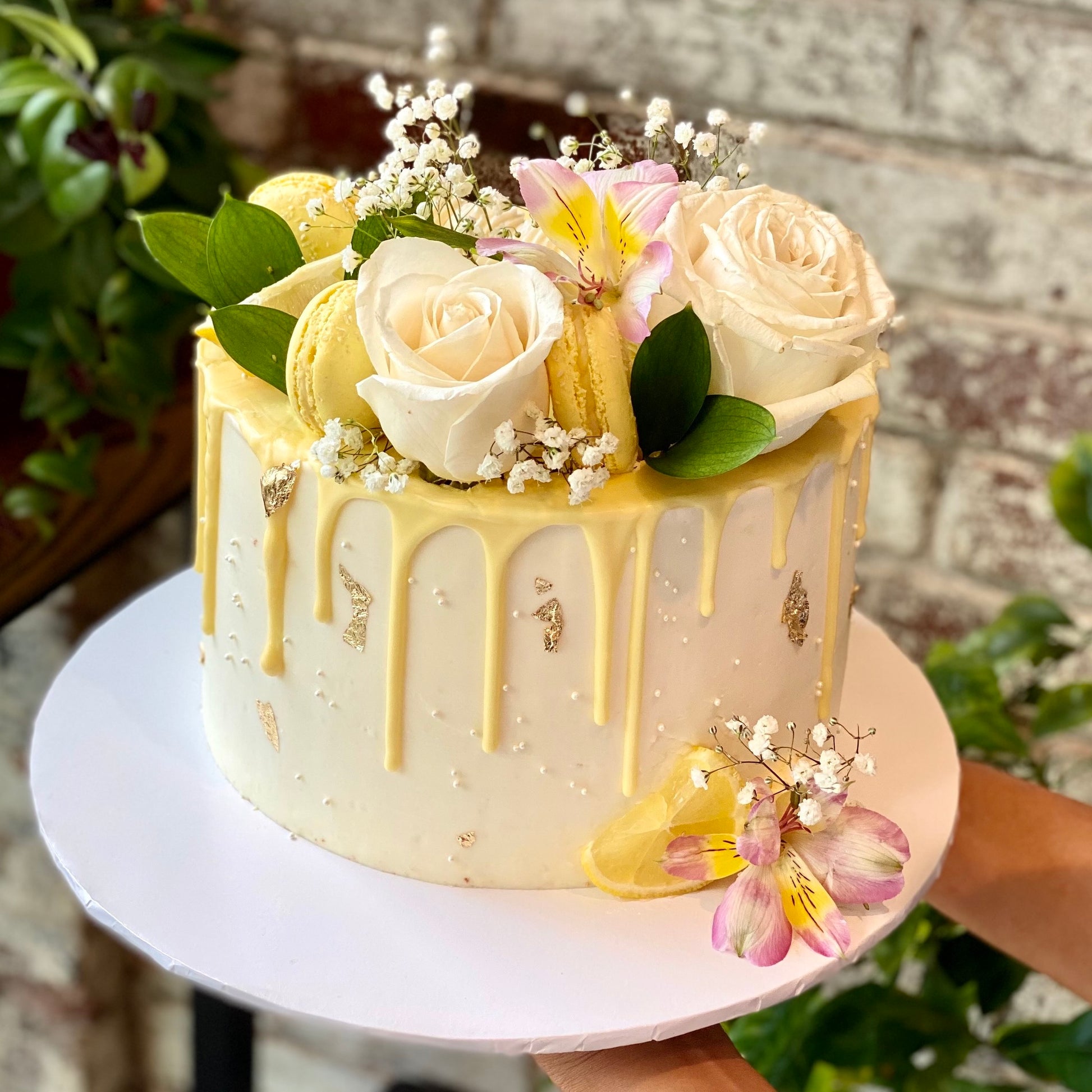 Wedding cake with golden colour and fresh flowers on top