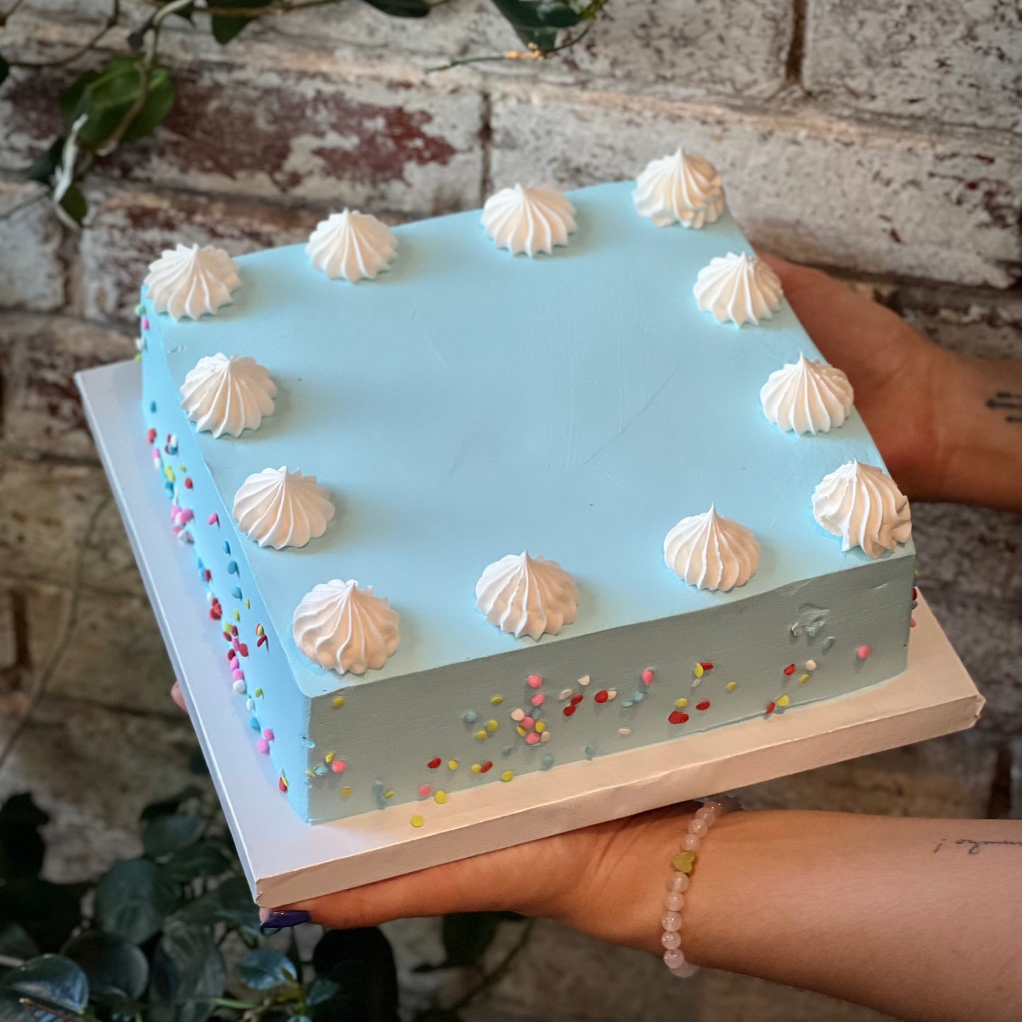 Square pastel blue cake with white dollops