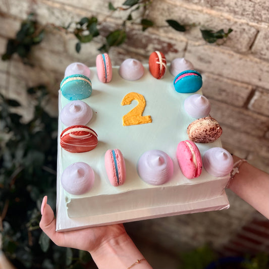 Square light blue cake with macarons and dollops