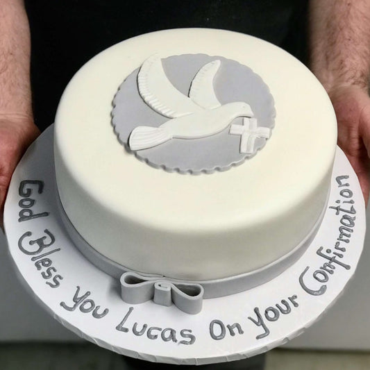 White cake with fondant dove and cross
