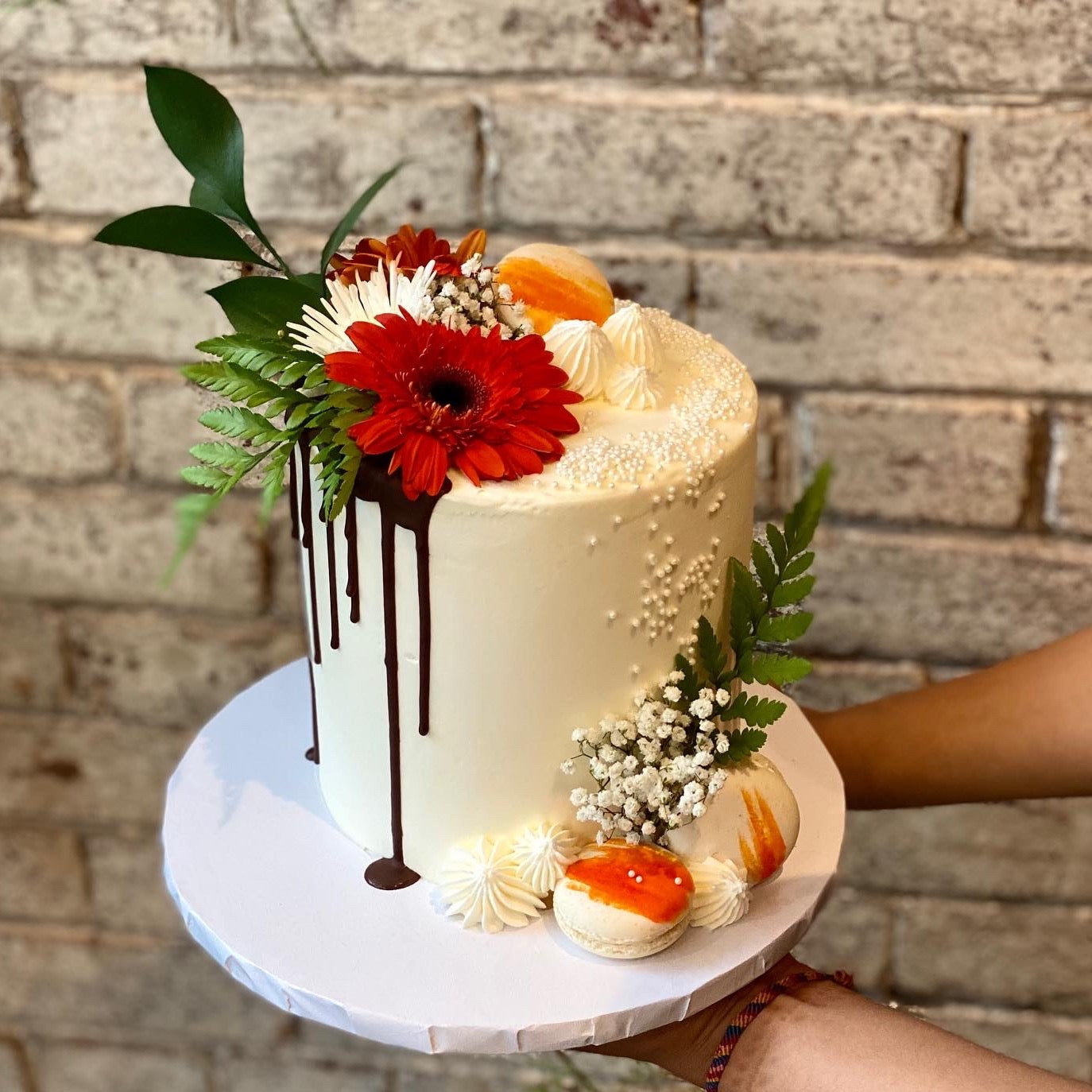 White cake with fresh red flower and chocolate drip
