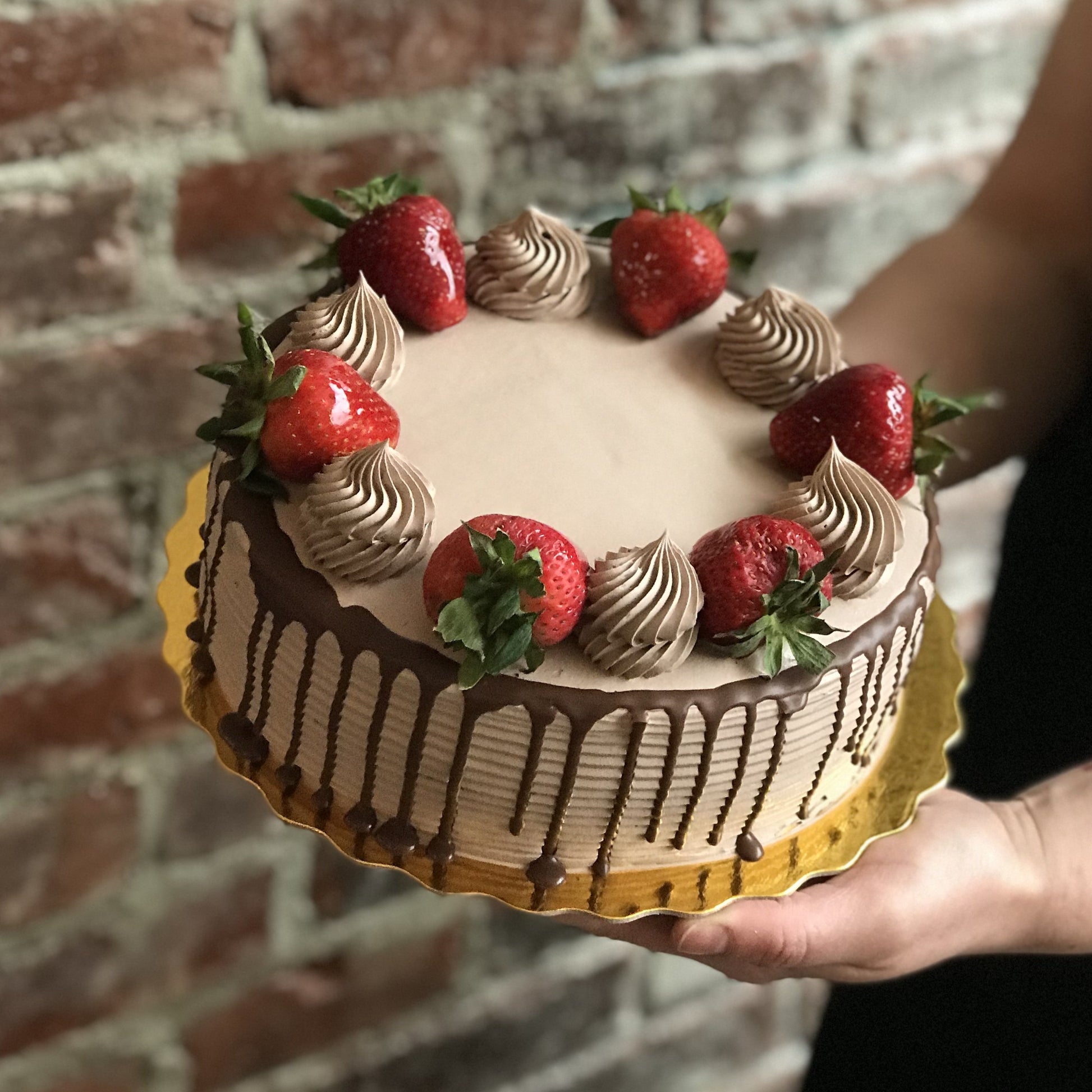 Chocolate cake with chocolate drip and fresh strawberries