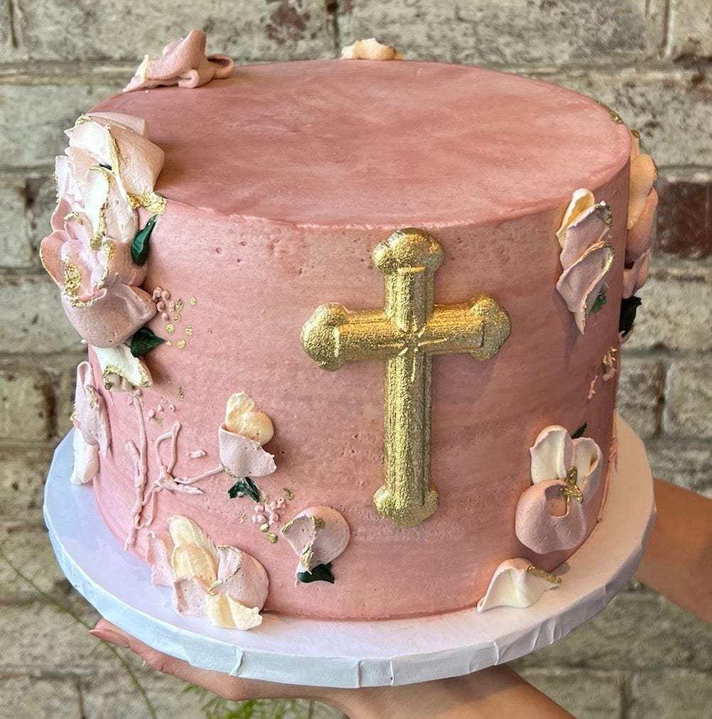 Pink cake with religious theme and gold cross