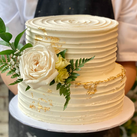 Two-tiered white cake with fresh flower