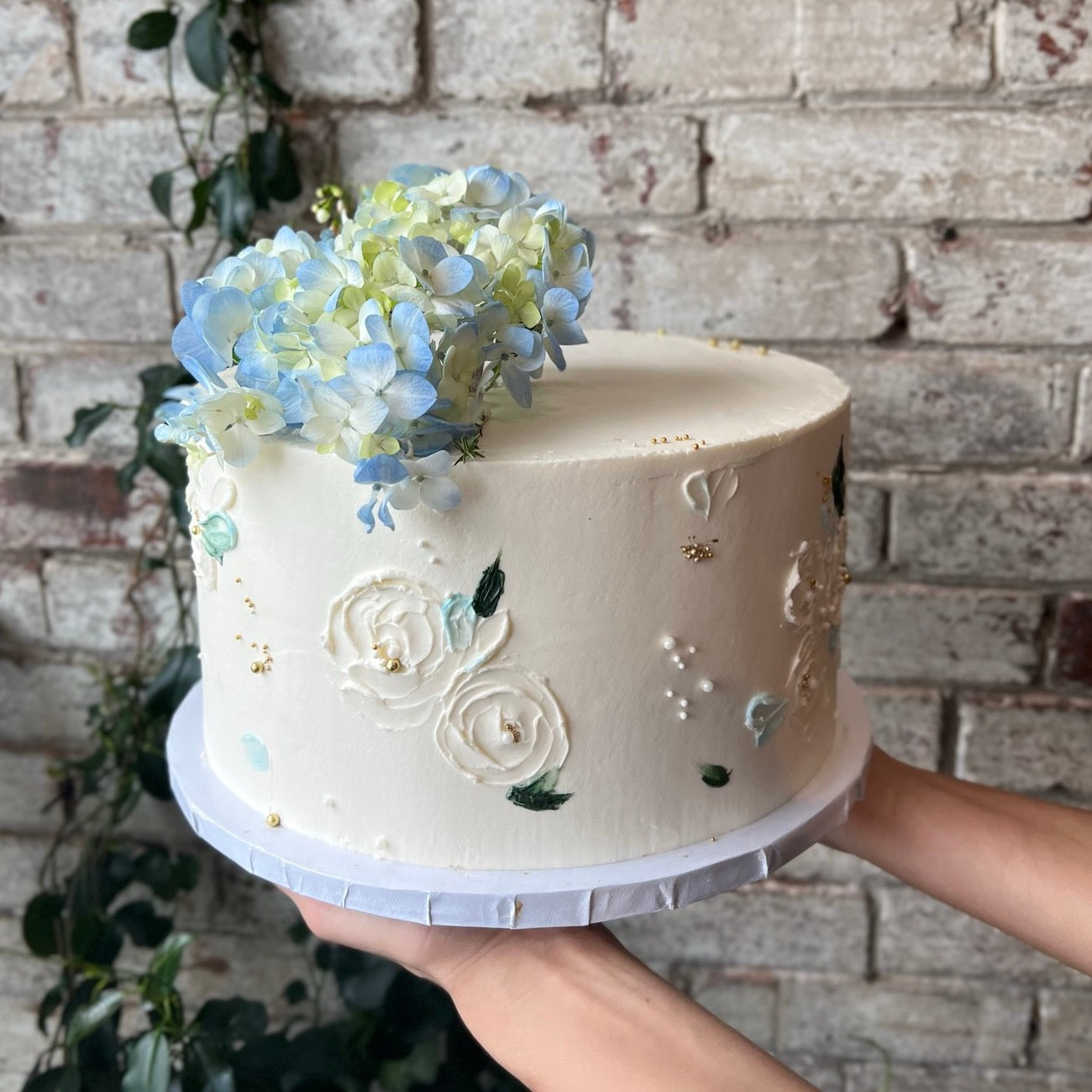White cake with blue fresh flowers