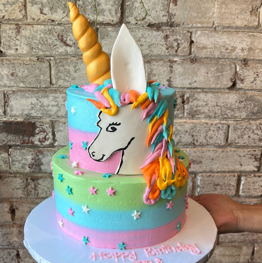 Two-tiered unicorn themed cake with pastel colours