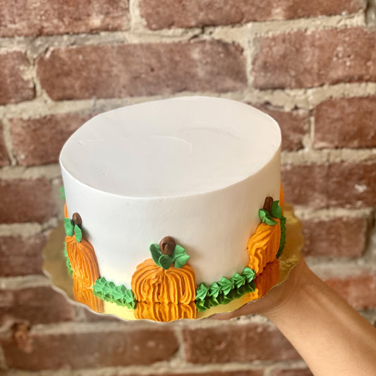 White cake decorated with orange pumpkin icing trim