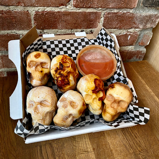 Skull shaped pizzas with marinara sauce dip