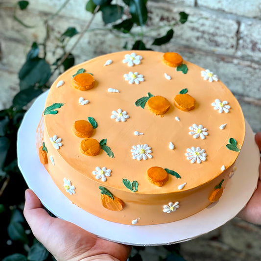 Orange cake with mandarins and white flowers