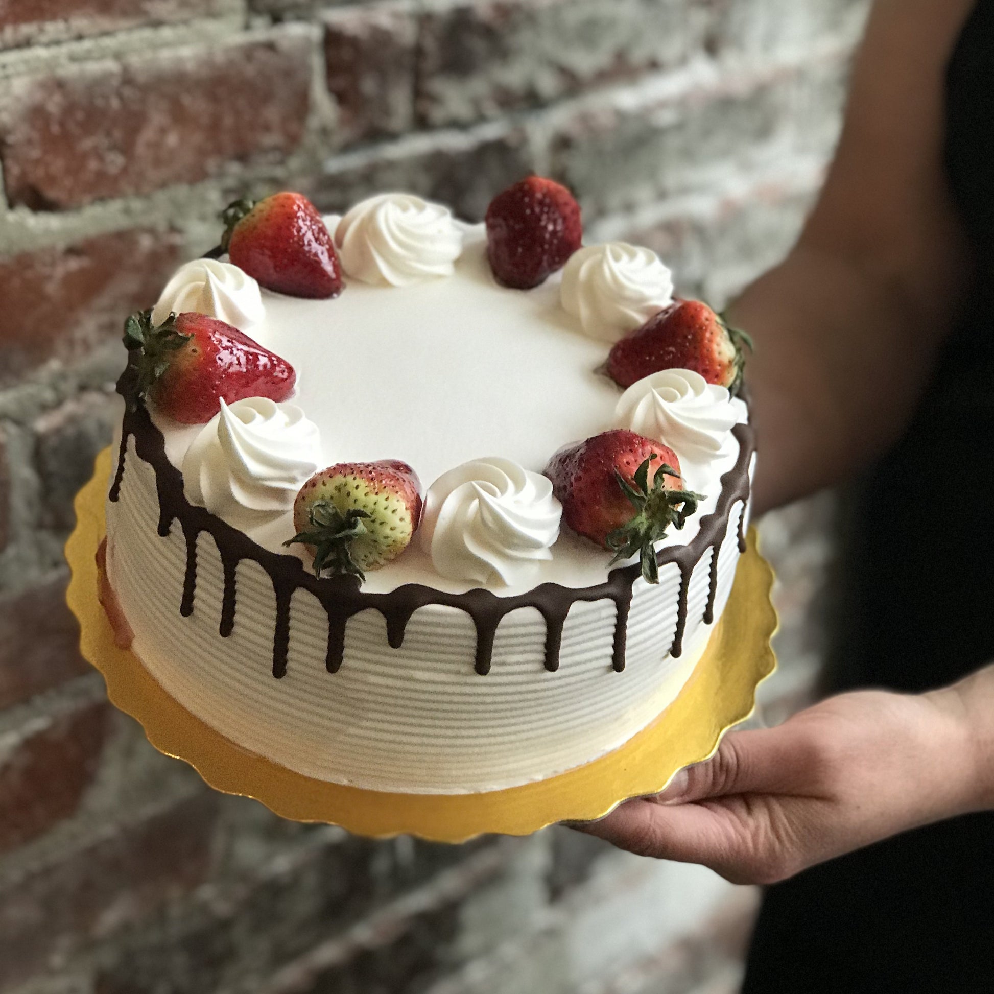 Vanilla cake with chocolate drip and fresh strawberries