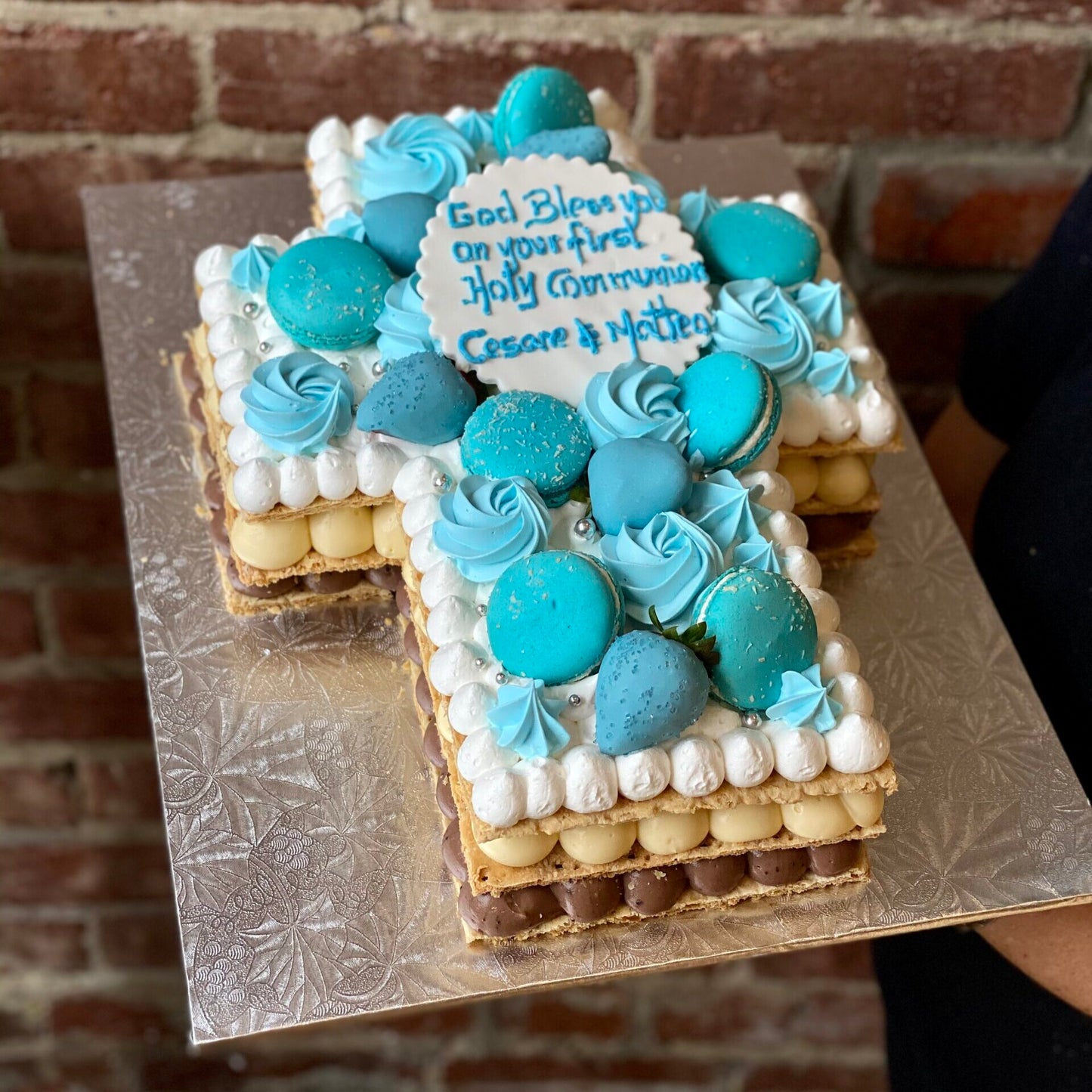 Cross-shaped religious cake with macarons