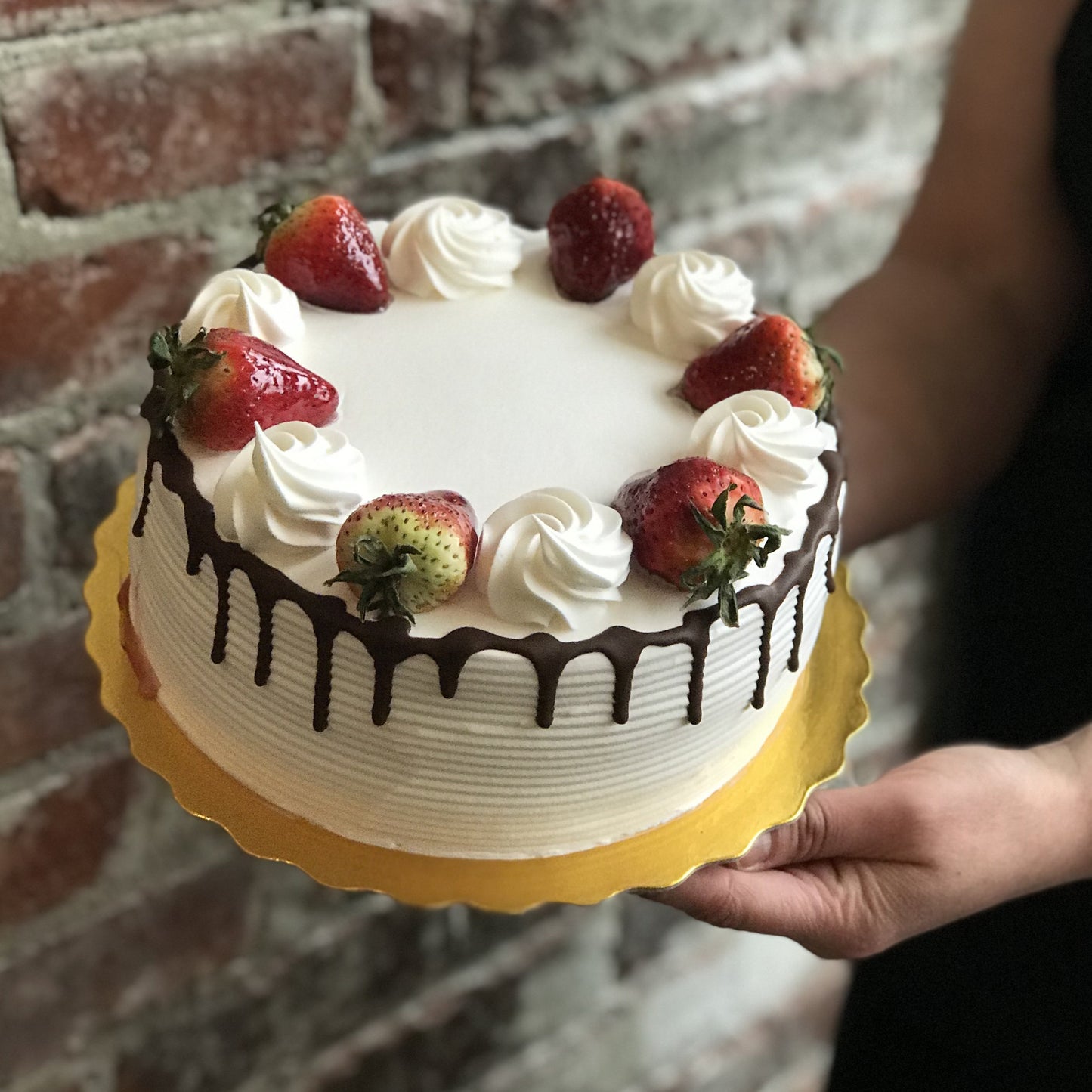 Vanilla cake with chocolate drip and fresh strawberries