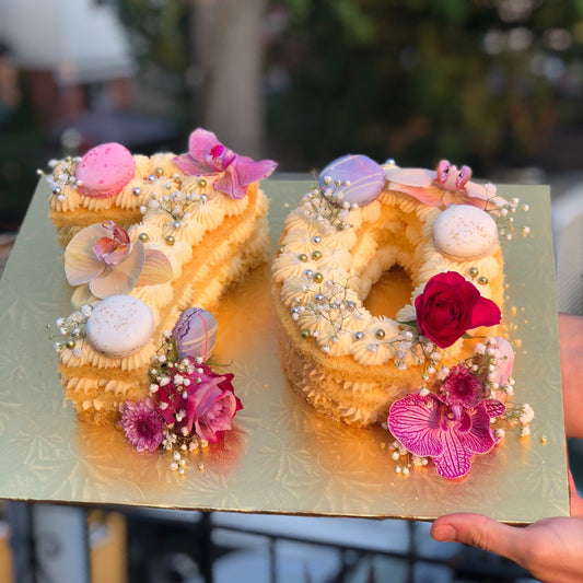 Cakes shaped as the number 70 with macarons and fresh flowers