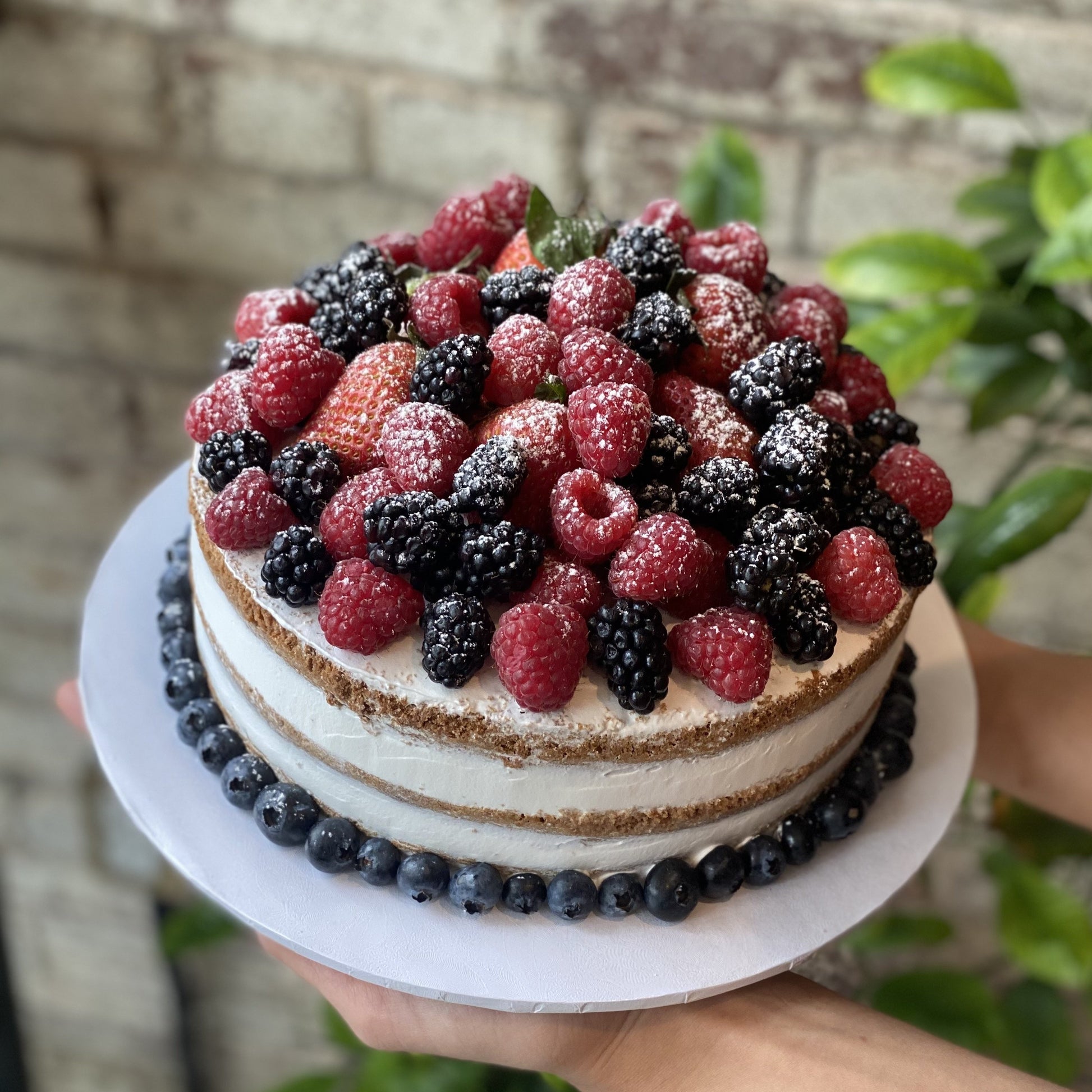 Cake with berries and powdered sugar on top