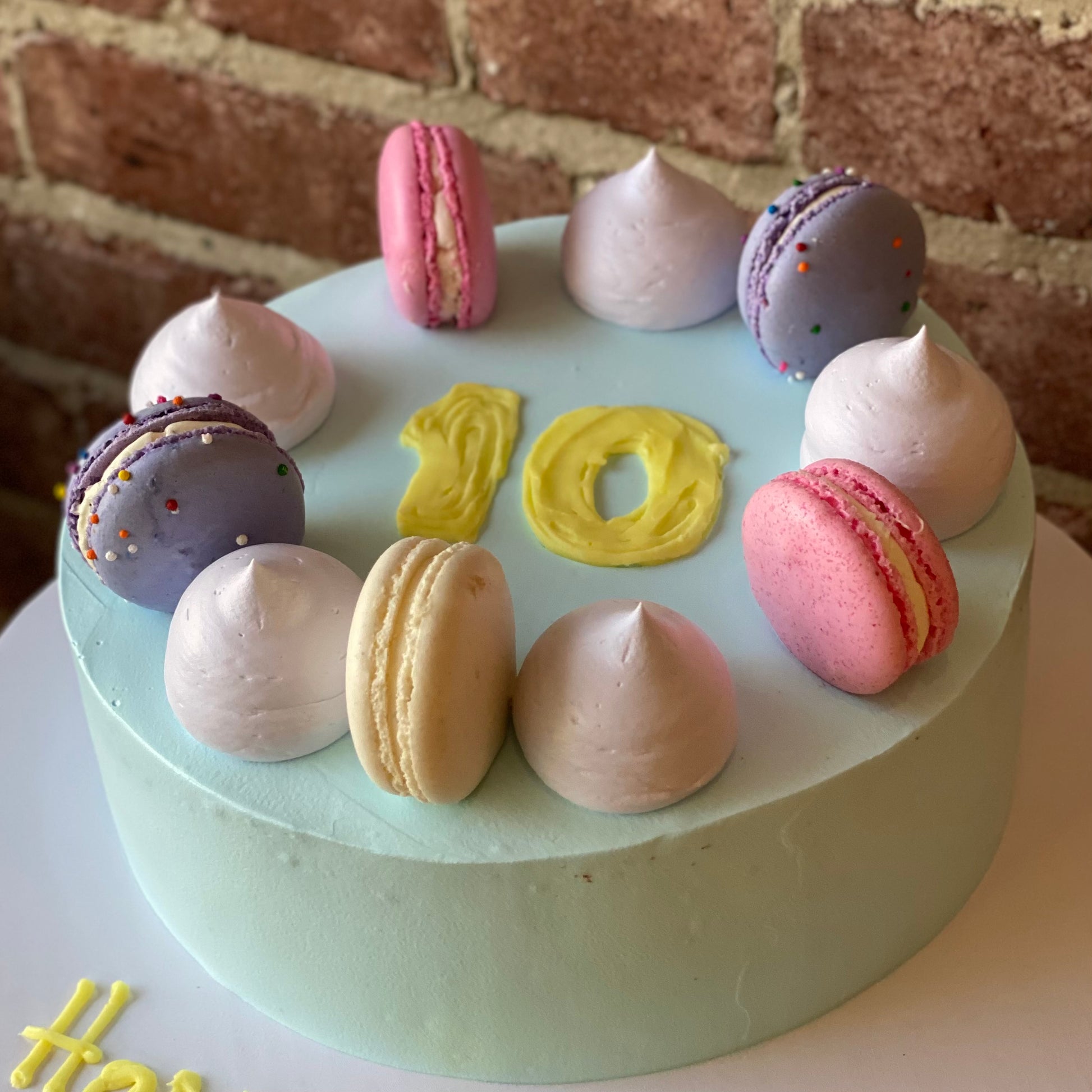 Pastel blue cake with macarons and dollops